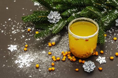 Taze deniz dikenli meyveli düşük alkollü meyve kokteyli. Noel ya da yeni yıl tatlı içeceği, köknar dalları. Siyah taş arkaplan, boşluğu kopyala