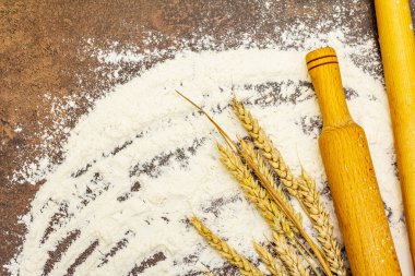 Dağıtılmış un, tahıldan kulaklar ve tahta raptiyeler. Pişirme kavramı, taş beton arkaplan, kopyalama alanı