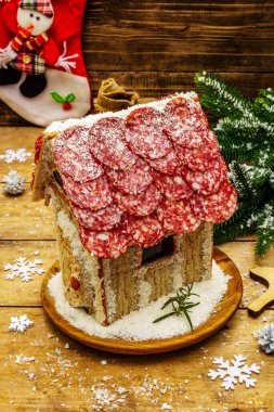 Şarküteri köşkü ya da Noel 'in en yeni yemek modası olarak Et Kulübesi. Geleneksel dekoru ve sembolleri olan yeni yıl keto kurabiyesi evi. Beyaz kar arkaplanı, kopyalama alanı