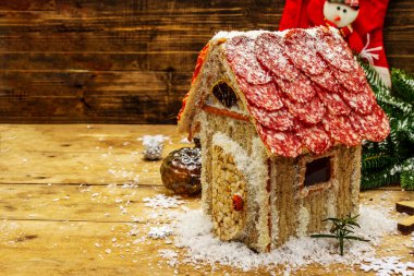 Şarküteri köşkü ya da Noel 'in en yeni yemek modası olarak Et Kulübesi. Geleneksel dekoru ve sembolleri olan yeni yıl keto kurabiyesi evi. Beyaz kar arkaplanı, kopyalama alanı