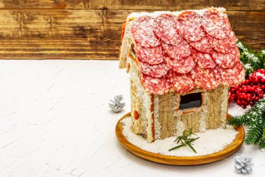 Şarküteri köşkü ya da Noel 'in en yeni yemek modası olarak Et Kulübesi. Geleneksel dekoru ve sembolleri olan yeni yıl keto kurabiyesi evi. Beyaz kar arkaplanı, kopyalama alanı