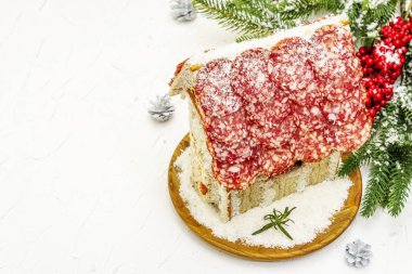 Şarküteri köşkü ya da Noel 'in en yeni yemek modası olarak Et Kulübesi. Geleneksel dekoru ve sembolleri olan yeni yıl keto kurabiyesi evi. Beyaz kar arkaplanı, kopyalama alanı