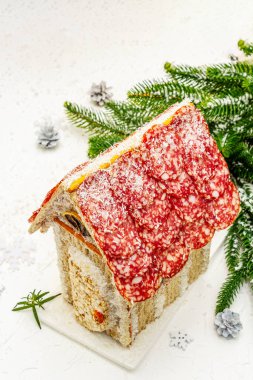 Şarküteri köşkü ya da Noel 'in en yeni yemek modası olarak Et Kulübesi. Geleneksel dekoru ve sembolleri olan yeni yıl keto kurabiyesi evi. Beyaz kar arkaplanı, kopyalama alanı