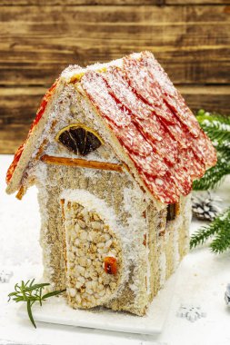 Şarküteri köşkü ya da Noel 'in en yeni yemek modası olarak Et Kulübesi. Geleneksel dekoru ve sembolleri olan yeni yıl keto kurabiyesi evi. Beyaz kar arkaplanı, kopyalama alanı