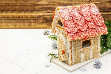 Şarküteri köşkü ya da Noel 'in en yeni yemek modası olarak Et Kulübesi. Geleneksel dekoru ve sembolleri olan yeni yıl keto kurabiyesi evi. Beyaz kar arkaplanı, kopyalama alanı