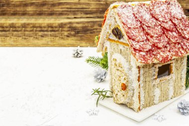 Şarküteri köşkü ya da Noel 'in en yeni yemek modası olarak Et Kulübesi. Geleneksel dekoru ve sembolleri olan yeni yıl keto kurabiyesi evi. Beyaz kar arkaplanı, kopyalama alanı