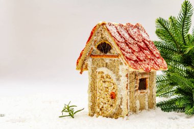 Şarküteri köşkü ya da Noel 'in en yeni yemek modası olarak Et Kulübesi. Geleneksel dekoru ve sembolleri olan yeni yıl keto kurabiyesi evi. Beyaz kar arkaplanı, kopyalama alanı