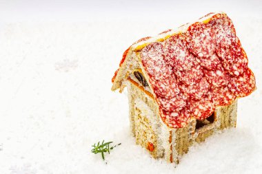 Şarküteri köşkü ya da Noel 'in en yeni yemek modası olarak Et Kulübesi. Geleneksel dekoru ve sembolleri olan yeni yıl keto kurabiyesi evi. Beyaz kar arkaplanı, kopyalama alanı