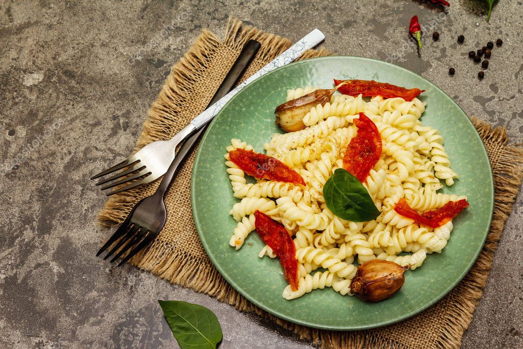 Pasta de fusilli sin gluten con ajo al horno y tomates. Comida