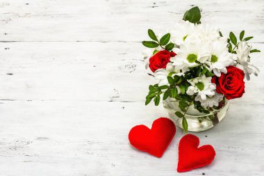 Bir buket taze çiçek ve kırmızı keçeli kalp. Sevgililer günü ya da düğün konsepti. Beyaz eski tahtalar arka plan