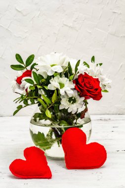 Bir buket taze çiçek ve kırmızı keçeli kalp. Sevgililer günü ya da düğün konsepti. Beyaz eski tahtalar arka plan