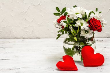 Bir buket taze çiçek ve kırmızı keçeli kalp. Sevgililer günü ya da düğün konsepti. Beyaz eski tahtalar arka plan