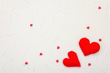 Kırmızı kalpli sevgililer günü konsepti. Yumuşak keçeli kalpler ve beyaz macun arka planda parlak bir dekor, düz yatıyordu