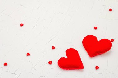 Kırmızı kalpli sevgililer günü konsepti. Yumuşak keçeli kalpler ve beyaz macun arka planda parlak bir dekor, düz yatıyordu