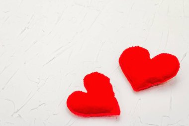 Kırmızı kalpli sevgililer günü konsepti. Yumuşak keçeli kalpler ve beyaz macun arka planda parlak bir dekor, düz yatıyordu