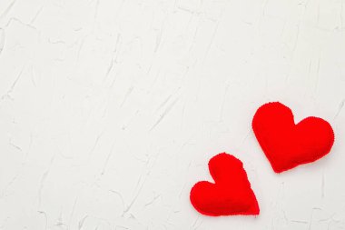 Kırmızı kalpli sevgililer günü konsepti. Yumuşak keçeli kalpler ve beyaz macun arka planda parlak bir dekor, düz yatıyordu