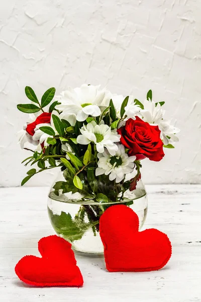 Bir buket taze çiçek ve kırmızı keçeli kalp. Sevgililer günü ya da düğün konsepti. Beyaz eski tahtalar arka plan