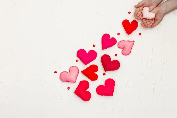 Valentijnsdag Concept Met Verspreide Harten Handen Van Kinderen Houden Een — Stockfoto