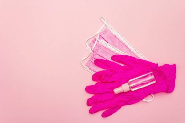 Fashion masks, glamour gloves and sanitizer isolated on pink background. Medical products for personal hygiene and the prevention of viral diseases. Coronavirus, COVID-19 pandemic, 2019-nCoV worldwide concept