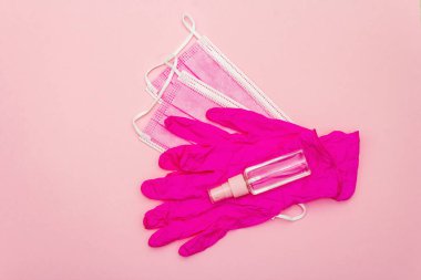 Fashion masks, glamour gloves and sanitizer isolated on pink background. Medical products for personal hygiene and the prevention of viral diseases. Coronavirus, COVID-19 pandemic, 2019-nCoV worldwide concept