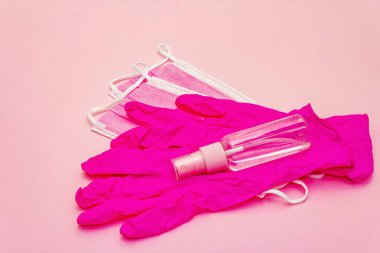 Fashion masks, glamour gloves and sanitizer isolated on pink background. Medical products for personal hygiene and the prevention of viral diseases. Coronavirus, COVID-19 pandemic, 2019-nCoV worldwide concept
