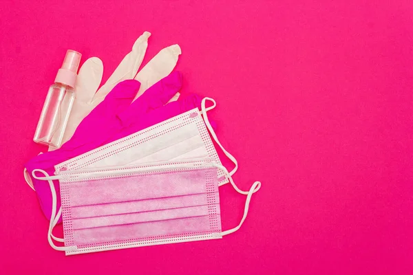 Fashion masks, glamour gloves and sanitizer isolated on pink background. Medical products for personal hygiene and the prevention of viral diseases. Coronavirus, COVID-19 pandemic, 2019-nCoV worldwide concept