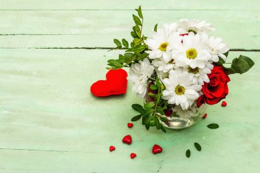 Red hearts with fresh fragrant rose and chrysanthemums. Valentine's day or Wedding romantic concept, top view, copy space. Old green wooden background