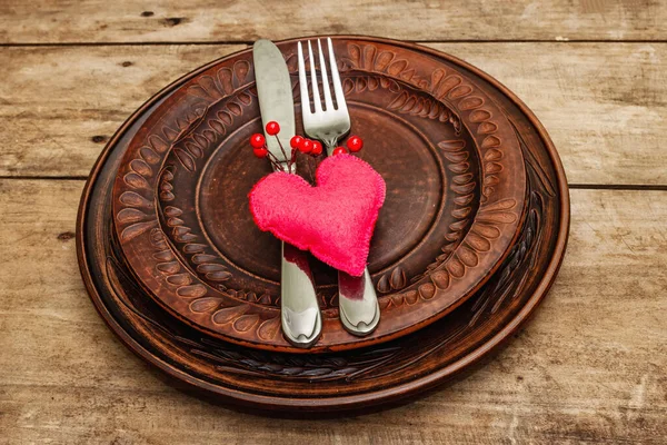 Romantic dinner table. Love concept for Valentine\'s or mother\'s day, wedding cutlery. Bouquet of fresh burgundy roses, vintage wooden boards background, rustic style