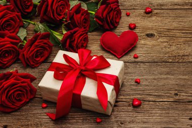 Sevgililer günü tebrik kartı geçmişi hediye kutuları, taze kırmızı güller ve çeşitli kalplerle dolu. Klasik ahşap masa. Düğün ya da doğum günü konsepti, metin yeri, düz yatak