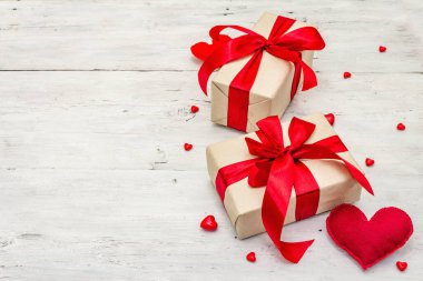 Sevgililer günü tebrik kartı geçmişi hediye kutuları, kırmızı kurdeleler ve çeşitli kalplerle dolu. Eski beyaz tahta arka plan. Düğün ya da doğum günü konsepti, düz yatak, metin için yer