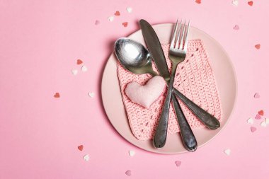 Romantik yemek masası. Sevgililer günü ya da anneler günü için aşk konsepti, düğün çatal bıçak takımı. Minimalist stil, gül tabakları, tığ işi peçete, dağınık hamur işi malzemesi, metin için yer