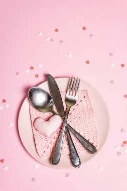 Romantik yemek masası. Sevgililer günü ya da anneler günü için aşk konsepti, düğün çatal bıçak takımı. Minimalist stil, gül tabakları, tığ işi peçete, dağınık hamur işi malzemesi, metin için yer