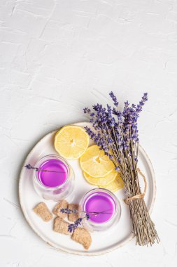 Limonata ve lavanta. Taze meyve ve kuru buket ile ferahlatıcı, düşük alkollü bir içecek. Beyaz macun arkaplan, üst görünüm