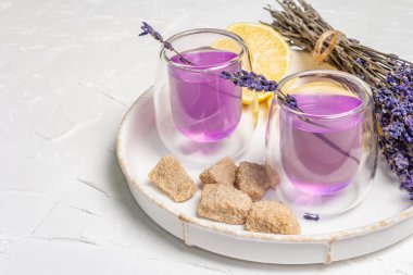 Limonata ve lavanta. Taze meyve ve kuru buket ile ferahlatıcı, düşük alkollü bir içecek. Beyaz macun arkaplanı