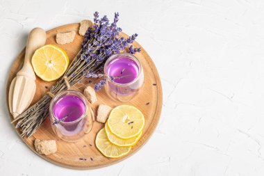 Limonata ve lavanta. Taze meyve ve kuru buket ile ferahlatıcı, düşük alkollü bir içecek. Beyaz macun arkaplanı, kopyalama alanı