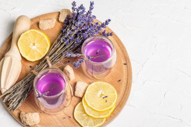 Limonata ve lavanta. Taze meyve ve kuru buket ile ferahlatıcı, düşük alkollü bir içecek. Beyaz macun arkaplanı, kopyalama alanı