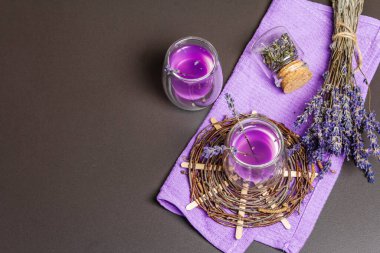 Taze lavanta menekşeli kokteyl, siyah taş beton arka planda. İçki bardakları, kuru buket, hasır tezgah, leylak peçete, üst manzara.