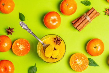 Taze portakal ve mandalinalardan tatlı meyve jölesi. Açık yeşil arka planda mis kokulu, güneşli, sağlıklı bir tatlı.