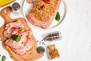 Çeşit çeşit organik et. Domuz filetosu ve ızgara, pişirme veya kızartma için biftek. Beyaz macun arkaplanındaki tanecikler ve yağ, kopyalama alanı