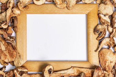 Kurutulmuş mantar Boletus edulis (Penny bun, Cep, Porcini) beyaz arka planda izole edilmiştir. Tahta çerçeve, vejetaryen (vegan) sağlıklı yiyecekler için malzeme