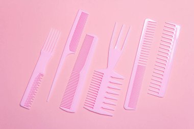 Pembe arka planda saç tarakları. Profesyonel dekorasyon araçları, güzellik blogcusu konsepti, üst görünüm