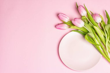 Nazik pembe arka planda laleleri olan şenlikli, yaratıcı pembe masa. Sevgililer günü, düğün, doğum günü, kadınlar ve anneler günü. Düz yatış, üst görünüm