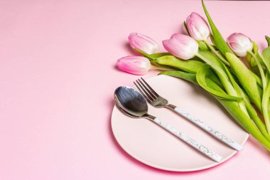 Nazik pembe arka planda laleleri olan şenlikli, yaratıcı pembe masa. Sevgililer günü, düğün, doğum günü, kadınlar ve anneler günü. Düz yat, boşluğu kopyala