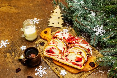 Beyaz çikolatalı ve soslu çilekli turta, sıcak kokulu çay. Noel ağacı ve yeni yıl dekorasyonu, neşeli bir ruh hali. Taş beton arka plan, kapat