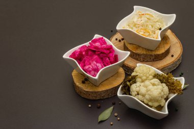 Farklı türde lahana turşusu. Mayalanmış yiyecekler sağlığınız için harikadır. Probiyotik beslenme konsepti, seramik kaseler ve ahşap tezgah, kopyalama alanı