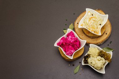 Farklı türde lahana turşusu. Mayalanmış yiyecekler sağlığınız için harikadır. Probiyotik beslenme konsepti, seramik kaseler ve ahşap tezgah, üst manzara.