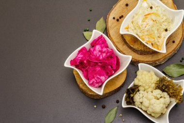 Farklı türde lahana turşusu. Mayalanmış yiyecekler sağlığınız için harikadır. Probiyotik beslenme konsepti, seramik kaseler ve ahşap tezgah, üst manzara.