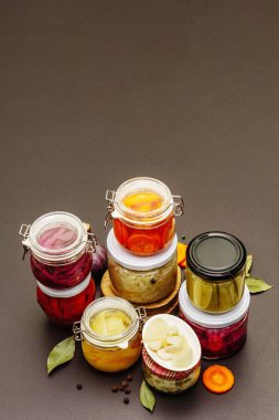 Cam kavanozlarda mayalanmış sebzeler. Mevsimlik sebze konsepti, sağlıklı yaşam tarzı için probiyotik gıdası. Siyah taş arkaplan, boşluğu kopyala