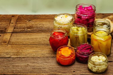 Cam kavanozlarda mayalanmış sebzeler. Mevsimlik sebze konsepti, sağlıklı yaşam tarzı için probiyotik gıdası. Eski tahta tablo, kopyala alanı