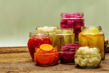 Cam kavanozlarda mayalanmış sebzeler. Mevsimlik sebze konsepti, sağlıklı yaşam tarzı için probiyotik gıdası. Eski tahta tablo, kopyala alanı